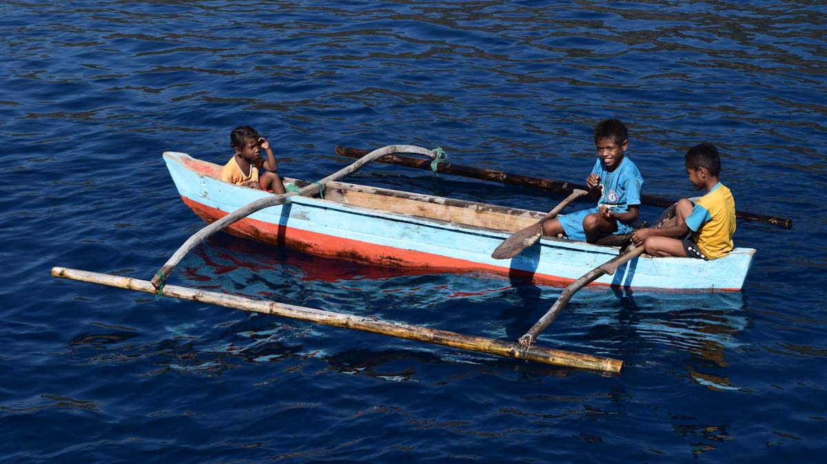 Kids on canoes at Pulau Serbete, Forgotten Islands of Indonesia