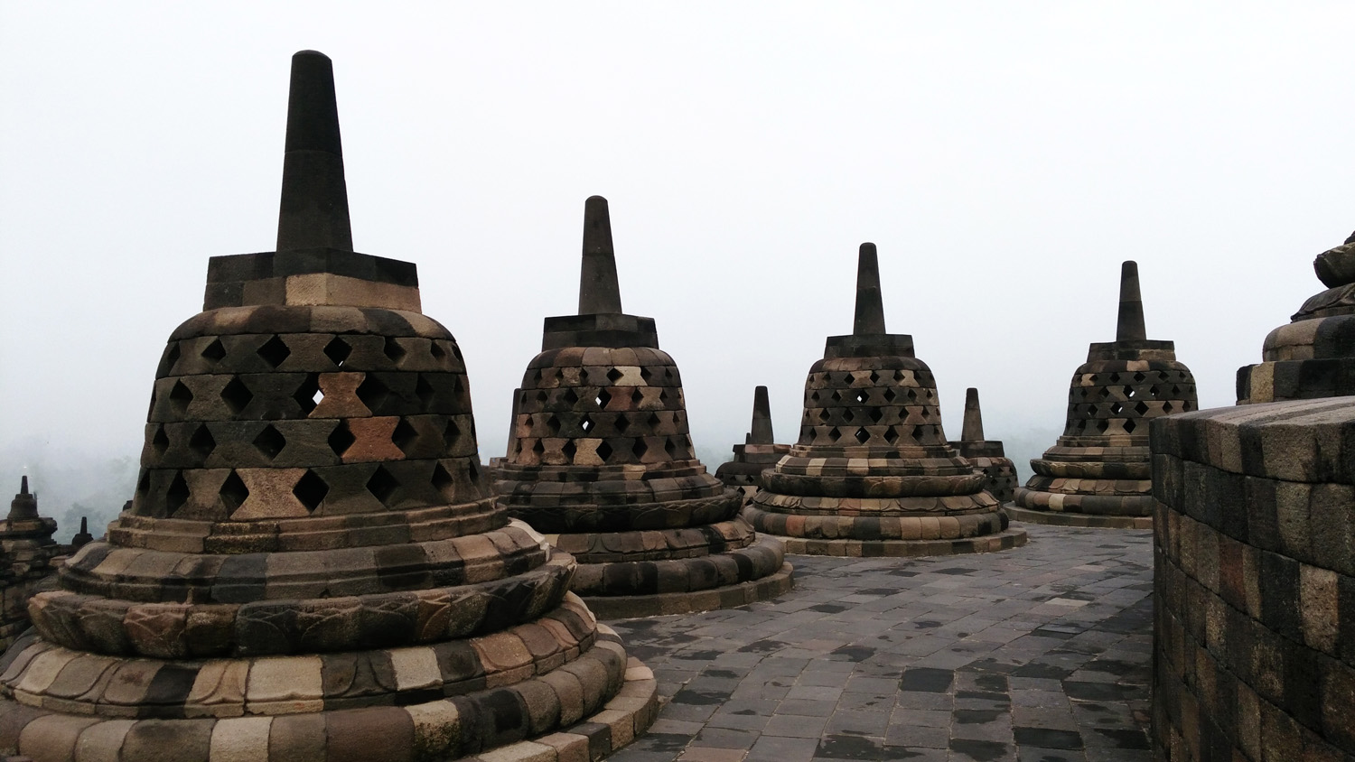 Statues of the Buddha sit inside the Borobudur's stupas